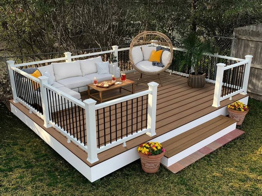 Composite decking with white railings, seating and planters after cleaning